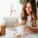 A woman opening up a package with a candle in it to do some paid product testing.