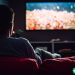A man alone in his dark living room watching Netflix.