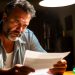 A stressed out looking man in his fifties looking at an unexpected tax bill that came in his mail.