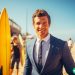 A man in a suit that is teaching surf lessons on the beach.