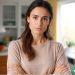 A female freelancer with her arms crossed and a disappointed look on her face. She is ready to fire a difficult client.