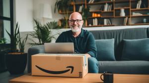 A man in his early 50s sitting with his laptop and an Amazon package.