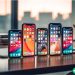 A row of old iPhones sitting on a desk.