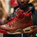 A man in his twenties holding an Air Jordan shoe for the camera.