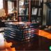 A stack of old DVDs sitting on a coffee table.