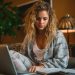 A young woman looking budget while sitting on a couch near her coffee table.